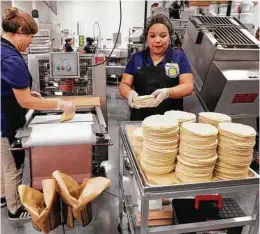  ??  ?? Josephine Jimenez and Leila Albarado make and stack tortillas in the bakery department in the new Katy Walmart.