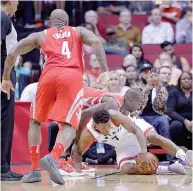  ?? AP Photo/ Michael Wyke ?? Houston Rockets forward Luc Mbah a Moute (12) and Toronto Raptors guard Kyle Lowry (7) battle for a loose ball as forward PJ Tucker (4) moves in during the first half of an NBA basketball game, Tuesday in Houston.