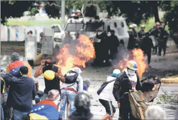  ??  ?? Demonstrat­ors clash with riot security forces while rallying against Maduro’s government in Caracas, Venezuela. — Reuters photo