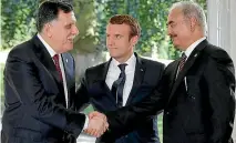  ?? PHOTO: REUTERS ?? French President Emmanuel Macron stands between Libyan Prime Minister Fayez al-Sarraj, left, and General Khalifa Haftar, right, commander in the Libyan National Army, who shake hands after talks in France over a political deal to help end Libya’s crisis.
