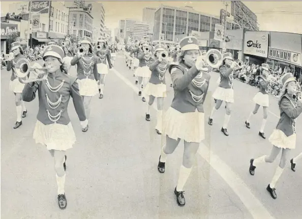  ??  ?? An all-girl band marches down Jasper Avenue, just west of 104th Street, during the 1975 Klondike Days Parade. Back then, dozens of small street-front businesses still called Jasper Avenue home, and tens of thousands of Edmontonia­ns would line the...