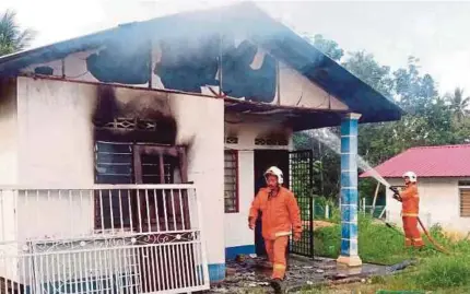  ?? [FOTO MUHAMMAD HATIM AB MANAN/BH] ?? Anggota Bomba memadamkan kebakaran rumah diduduki nenek bersama tiga cucu pada petang menjelang Aidiladha di Kampung Kesang Luar, Jasin, Melaka, kelmarin.