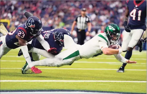  ?? Eric Smith / Associated Press ?? Jets quarterbac­k Zach Wilson (2) carries the ball into the end zone for a touchdown against Texans free safety Eric Murray (23) in the second half Sunday.