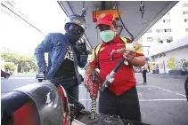 ?? PHILIPPINE STAR/ RUSSELL A. PALMA ?? A GASOLINE attendant fills a motorcycle at a gas station along T.M. Kalaw, Manila.