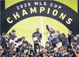  ?? EMILEE CHINN/GETTY ?? Jonathan Mensah brings his Crew teammates the MLS Cup after the club’s 3-0 win over the Sounders in the league final Saturday night in Columbus, Ohio.