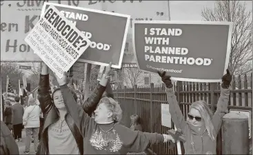  ?? Jim Salter / The Associated Press ?? A Planned Parenthood supporter and opponent try to block each other’s signs during a protest and counter-protest Saturday in St. Louis.