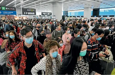  ?? AP ?? Travellers wear protective face masks at the Hong Kong train station to ward off the new coronaviru­s.