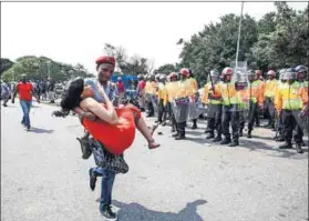  ?? Photo: Thuli Dlamini/Gallo Images/The Times ?? Unrest: The Economic Freedom Fighters’ Nathi Phetha carries injured student Bongeka Mntaka.