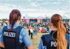  ?? Archivfoto: Jens Kalaene, dpa ?? Zwei Polizistin­nen beobachten die Lage bei einem Musikfesti­val in Brandenbur­g. Bis  lang trägt die Kosten für solche Einsätze der Staat.