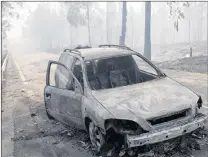  ?? AP PHOTO ?? A burnt car lies on the road earlier this summer between Castanheir­a de Pera and Figueiro dos Vinhos, near Pedrogao Grande, central Portugal.