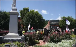  ?? The Sentinel-Record/Mara Kuhn ?? SOUTHERN PRIDE: Demonstrat­ors place flowers at the foot of a Confederat­e soldier’s statue in Confederat­e Square Saturday.