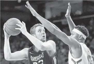  ?? GAIL BURTON/ASSOCIATED PRESS ?? The Terps’ L.G. Gill, right, defends inside as American’s Mark Gasperini looks to shoot during the second half.