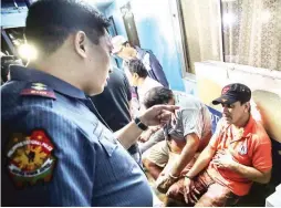  ?? (Jun Ryan Arañas) ?? MALATE SHABU BUST – A police officer questions two barangay tanods and a parking attendant from whom three sachets of shabu were seized during a drug bust in Malate, Manila, Wednesday night.