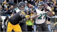  ?? AP/DON WRIGHT ?? Jaguars running back Leonard Fournette (right) carries the ball with Steelers defensive end Stephon Tuitt in pursuit during the second half Sunday in Pittsburgh. Fournette finished with 109 yards rushing and three touchdowns as the Jaguars won 45-42.