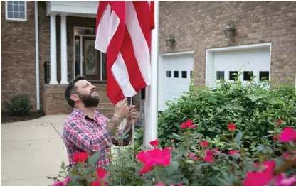  ?? JULIA RENDLEMAN/SUN-TIMES ?? FBI agent James Rudisill takes down a flag at sunset at his home in 2020. The Army veteran is hoping the Supreme Court takes his case, which could help other vets access educationa­l benefits they earned under more than one GI Bill.