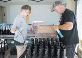  ??  ?? Savannah Zastrow, left, and Tom Williams, pyrotechni­cians with Fireworks by Grucci, prepare for a Fourth of July fireworks show at the Fiesta Rancho.