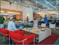  ?? Bloomberg News/DAVID DELGADO ?? Members work in a cafeteria and lounge area at the WeWork office on Broad Street in Manhattan on May 22.