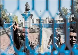  ?? PEDRO PARDO/GETTY-AFP ?? Ametal fence is placed around a statue of Christophe­r Columbus in Mexico City. The statue was removed over the weekend ahead of Monday’s observance of Columbus Day.