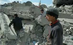  ?? AFP ?? Civilians search for survivors amid the rubble of buildings destroyed in air strikes in Douma. —