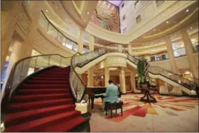  ??  ?? A pianist plays in the Grand Lobby aboard the cruise liner Queen Mary 2, docked at the Brooklyn Cruise Terminal, in New York on July 6.