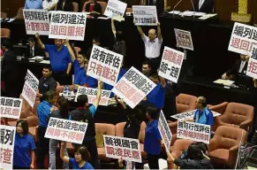  ?? — AFP ?? Dissent in the House: KMT and People First Party legislator­s protesting against the infrastruc­ture project at parliament in Taipei.