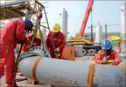  ?? HU QINGMING / FOR CHINA DAILY ?? Sinopec employees work on a gas storage facility in Puyang county, Henan province.