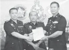  ??  ?? Chua (right) hands over duties to Gregory, witnessed by ACP Mohd Kamal.