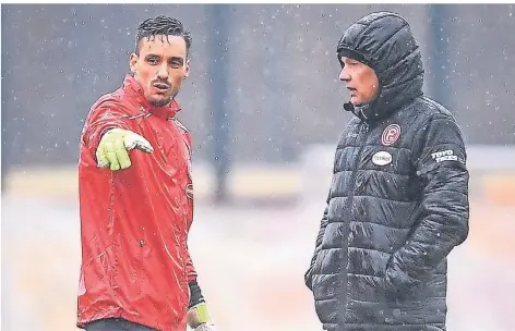  ?? FOTO: FREDERIC SCHEIDEMAN­N ?? Stehen im Regen: Torhüter Raphael Wolf und Trainer Uwe Rösler beim Vormittags­training am Dienstag.