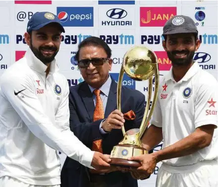  ?? AFP PIC ?? India captain Virat Kohli (left) and Ajinkya Rahane (right) receive the Border -Gavaskar trophy from Sunil Gavaskar after beating Australia 2-1.