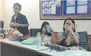  ??  ?? The three female suspects put on make-up while being detained at Mae Sai immigratio­n office.