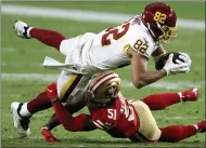  ?? CHRISTIAN PETERSEN — GETTY IMAGES ?? Tight end Logan Thomas of the Washington Football Team is tackled after a reception by linebacker Azeez Al-Shaair of the San Francisco 49ers.