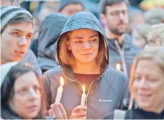  ?? — Reuters photo ?? People mourn the loss of life as they hold a vigil for the victims.