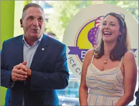  ?? SARAH GORDON THE DAY ?? Owner Laura Beckham laughs with Mayor Michael Passero during the reopening of Berry’s Ice Cream &amp; Candy Bar last week at the shop’s new location at 90-B Bank St. in New London.