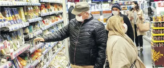  ?? IMAGO-BILD: SCHNEIDER ?? Supermarkt­besucher mit Schutzmask­en: So wie in Wien könnte es bald auch in Deutschlan­d aussehen.