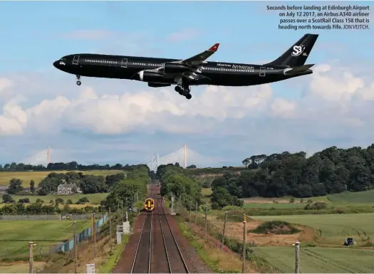  ?? JON VEITCH. ?? Seconds before landing at Edinburgh Airport on July 12 2017, an Airbus A340 airliner passes over a ScotRail Class 158 that is heading north towards Fife.