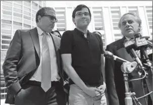  ?? The Associated Press ?? CONVICTED: Martin Shkreli, center, stops with his attorneys to talk to reporters Friday in front of federal court in New York. The former pharmaceut­ical CEO has been convicted on federal charges he deceived investors in a pair of failed hedge funds. A...