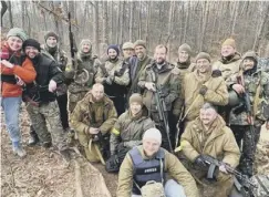  ?? ?? Shane, pictured in the centre holding the sniper rifle, says he has helped to train more than 500 Ukrainian fighters since arriving in the country