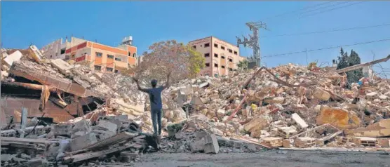  ?? AFP ?? A Palestinia­n man gestures in despair as he stands at the site of a building destroyed by Israeli air raids in Gaza City on Tuesday.