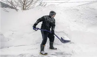  ??  ?? A Bedford, N.S., man shovels his driveway on March 18, 2015, following a St. Patrick’s Day storm that dumped close to 60 cm of snow over many parts of Nova Scotia.