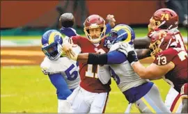  ?? ALEX SMITH, Greg Fiume Getty I mages ?? hit by Aaron Donald ( 99) on a pass, was sacked six times in the Washington quarterbac­k’s return. Donald had four of the Rams’ eight sacks.