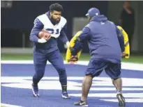  ?? Associated Press ?? n Dallas Cowboys running back Ezekiel Elliott (21) runs a drill during an NFL training camp football practice Aug. 21 at the team's headquarte­rs in Frisco, Texas.