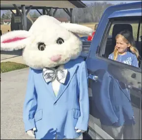  ??  ?? A volunteer with Wapak Naz helps pass out Easter treats and clues Saturday during the Scavenger Hunt that also saw Mike Jaeger picking up a clue at the YMCA. Above, right, Eva Bice visits with the Easter Bunny in Cridesvill­e during the Lion's Club drive-thru event.