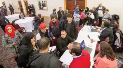  ?? CARLOS OSORIO PHOTOS/TORONTO STAR ?? Syrian refugees met employers at a job fair at the Toronto Plaza Hotel, where many government-assisted newcomers are being housed.