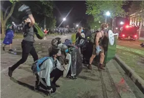  ?? MARK HOFFMAN/USA TODAY NETWORK ?? People throw things and harass law enforcemen­t near the Kenosha County Courthouse in Wisconsin.