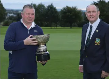  ??  ?? Gun Club Trophy winner Colm Cooney accepts the cup which has been played in the club since its foundation in 1928 from Baltinglas­s Golf Club captain Liam Horgan