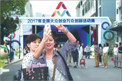  ?? WU KAI/ FOR CHINA DAILY ?? Selfie-taking visitors soak in the atmosphere at the 2017 Startup Week in Shanghai earlier this month.