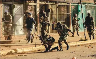  ??  ?? A member of the Zimbabwe National Army kneels to shoot at unarmed civilians in August 2018