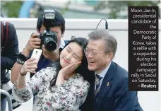  ?? — Reuters ?? Moon Jae-In, presidenti­al candidate of the Democratic Party of Korea, takes a selfie with a supporter during his election campaign rally in Seoul on Saturday.