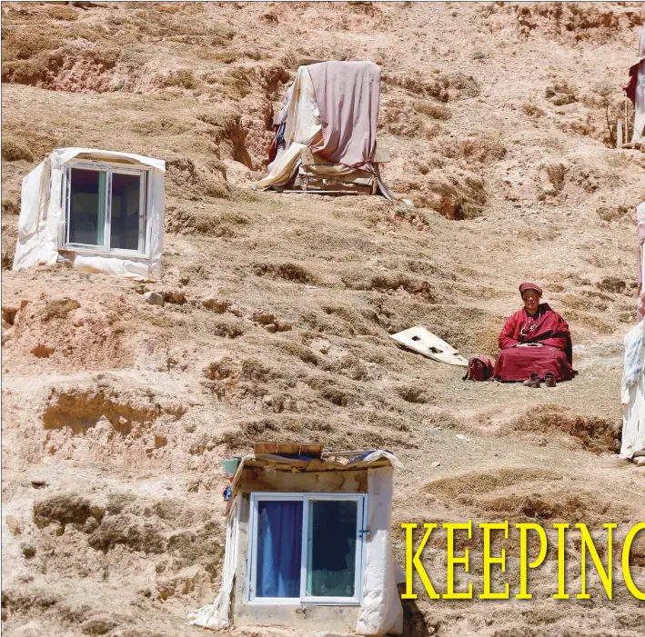  ?? Photos: Yang Hui/GT ?? Clockwise from top left: A nun mediates near her small home near the Yachen monastery complex in the Ganzi Tibetan Autonomous Prefecture, Sichuan Province. A woman carries a board as she makes her way through the complex. A bird’s-eye-view of the...