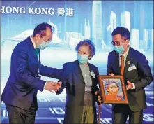  ?? EDMOND TANG / CHINA DAILY ?? Zhou Li ( right), deputy editor- in- chief of China Daily, presents a special souvenir to Annie Wu Suk- ching ( center), honorary chairman, Beijing Air Catering Co, during the Greater Bay Area Conference — GBA: The Way Forward in Hong Kong, on Wednesday.